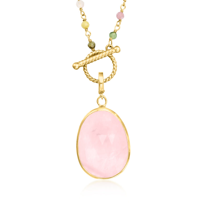Oval pink gemstone pendant with gold-tone bail on beaded toggle necklace