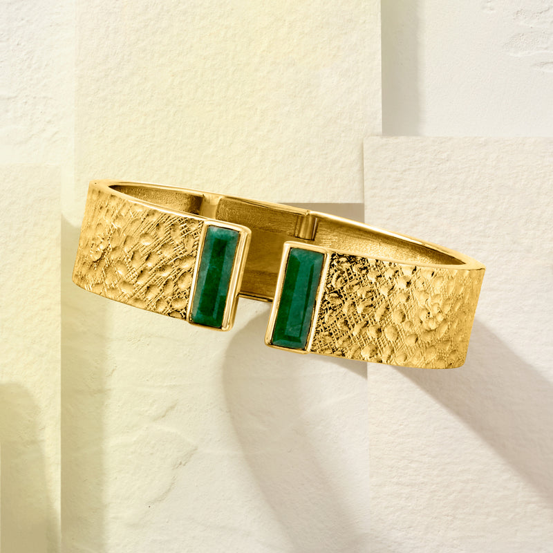 Textured gold cuff bracelet with two square emerald stones and open hinge clasp, side view