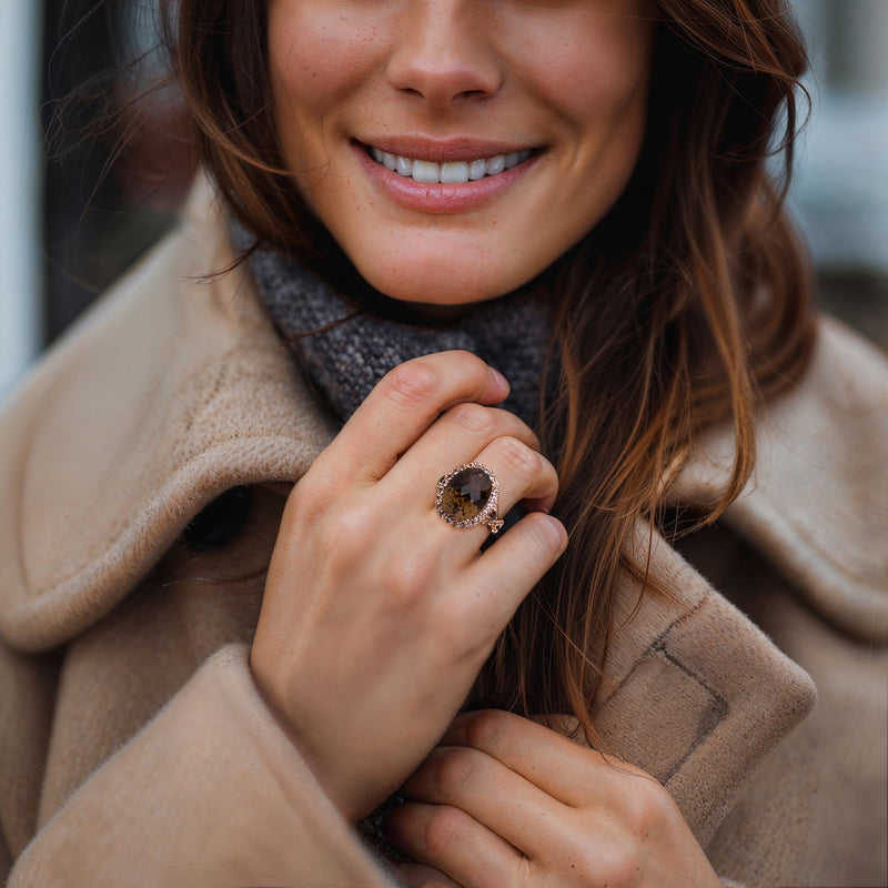 Le Vian ring on hand: oval brown gemstone with white halo in rose gold