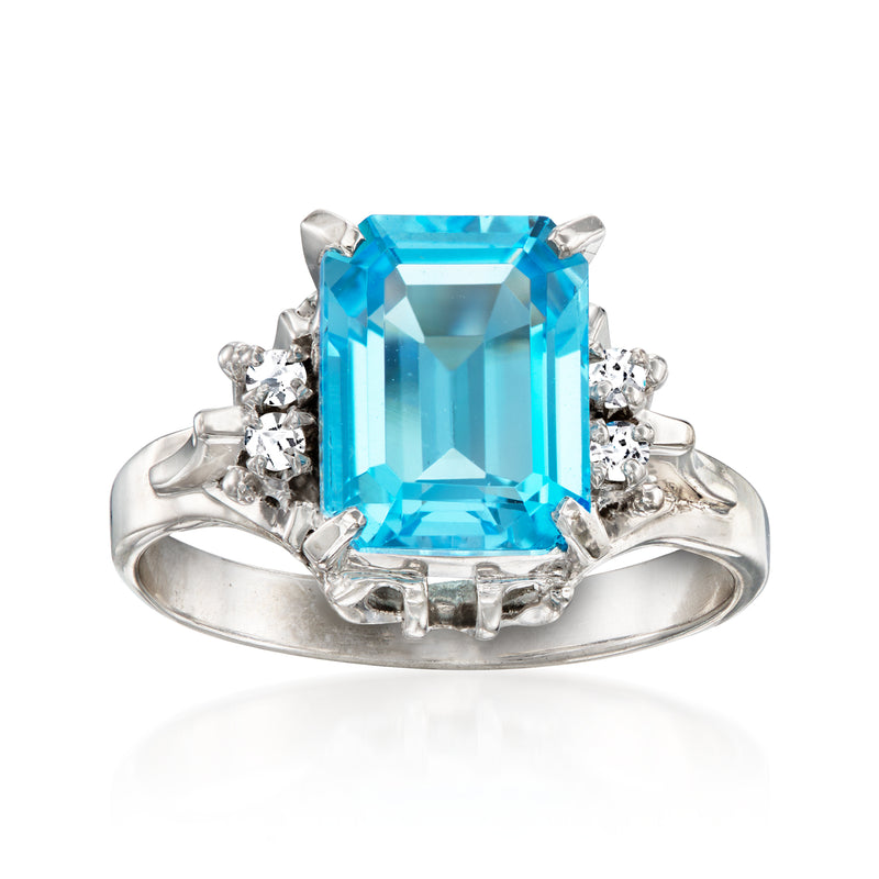 Platinum ring with large sky-blue gemstone and diamond accents, emerald-cut halo