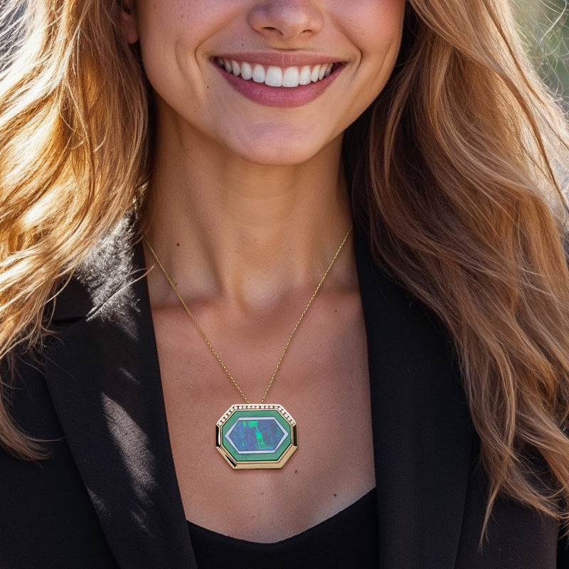Gold pendant necklace with octagonal green-framed blue gemstone and small diamond surround