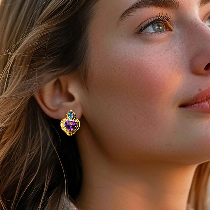 Heart stud earrings in 18kt yellow gold with purple and blue gemstones on ear
