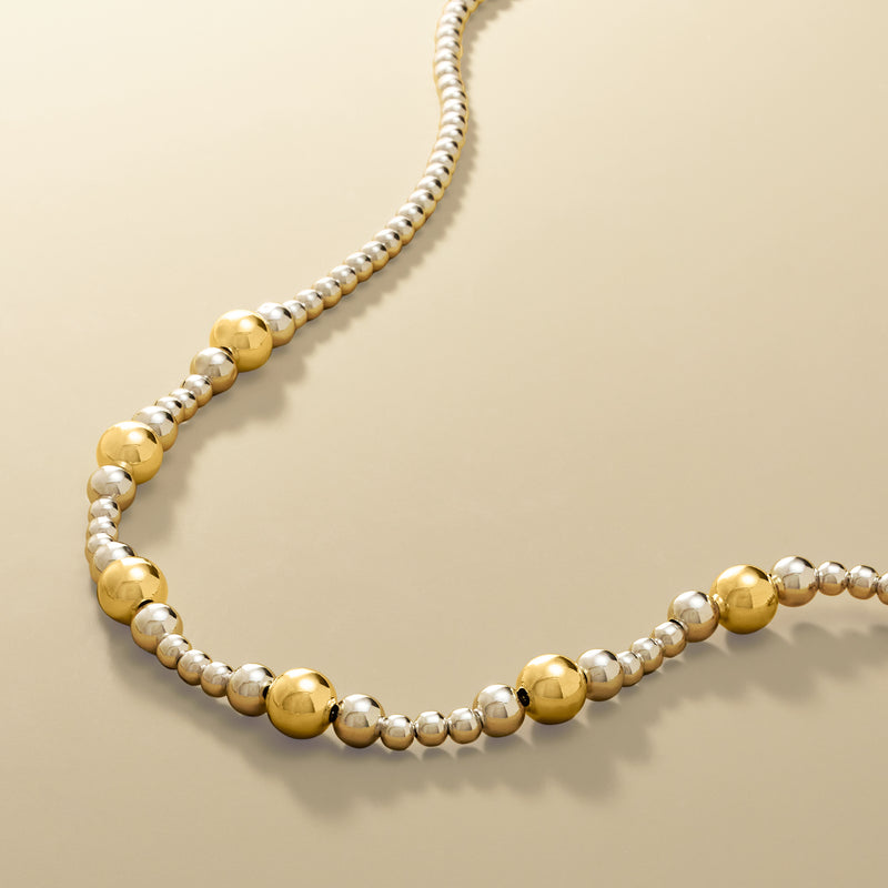 Angled graduated bead necklace with silver beads and gold over sterling spheres