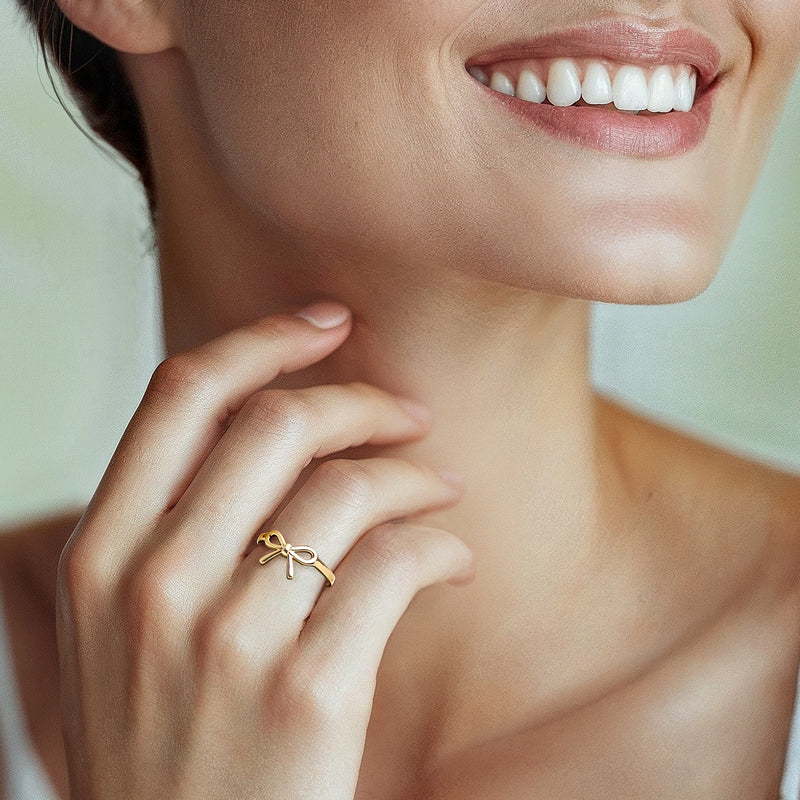 10kt yellow gold bow ring worn on finger, polished ribbon bow