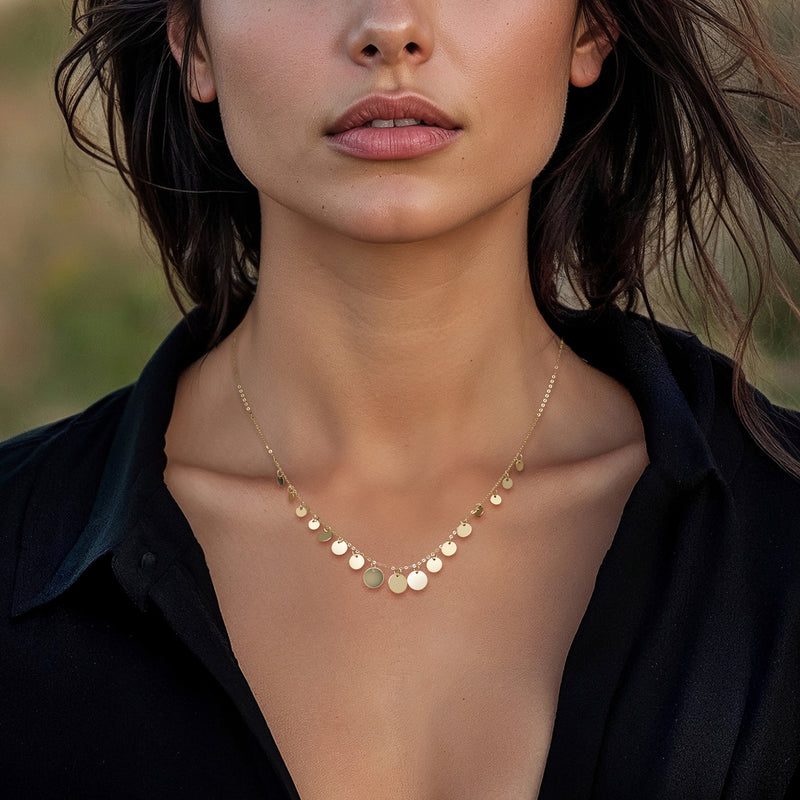 Yellow gold graduated disc drop necklace on neckline with round disc drops