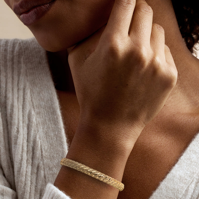Yellow gold mesh bangle bracelet worn on wrist