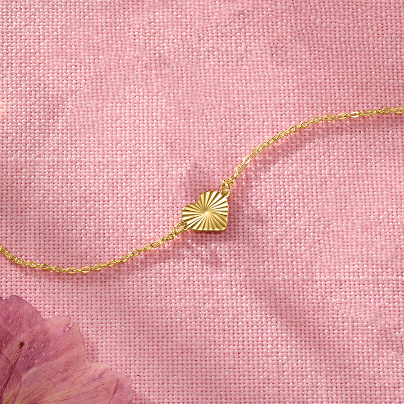 Yellow gold diamond-cut heart charm bracelet with small heart pendant on chain