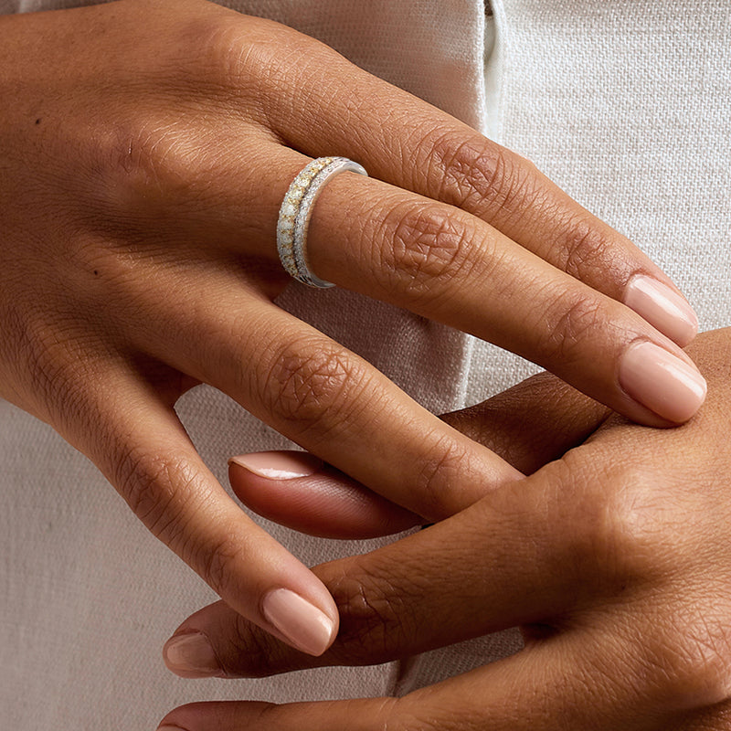 Three-row diamond ring on hand, yellow and white stones in 14kt white gold
