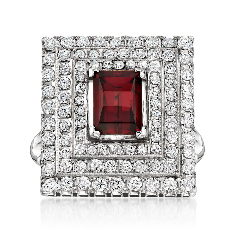 Platinum rectangular ring with red garnet centerpiece and diamond border and rows