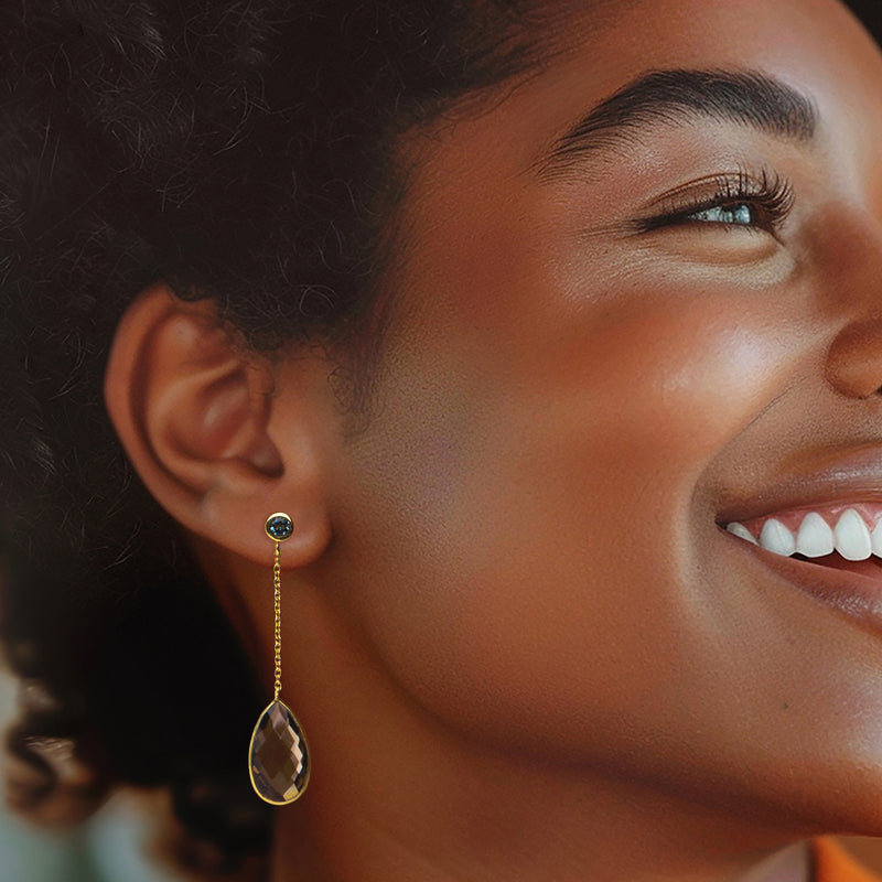 Gold drop earrings on model: blue topaz top with smoky quartz teardrop dangle