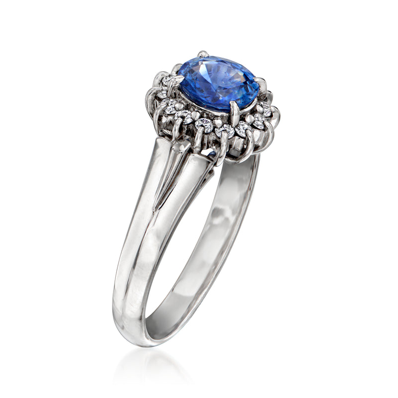Platinum sapphire ring with split shank and diamond cluster around oval blue stone