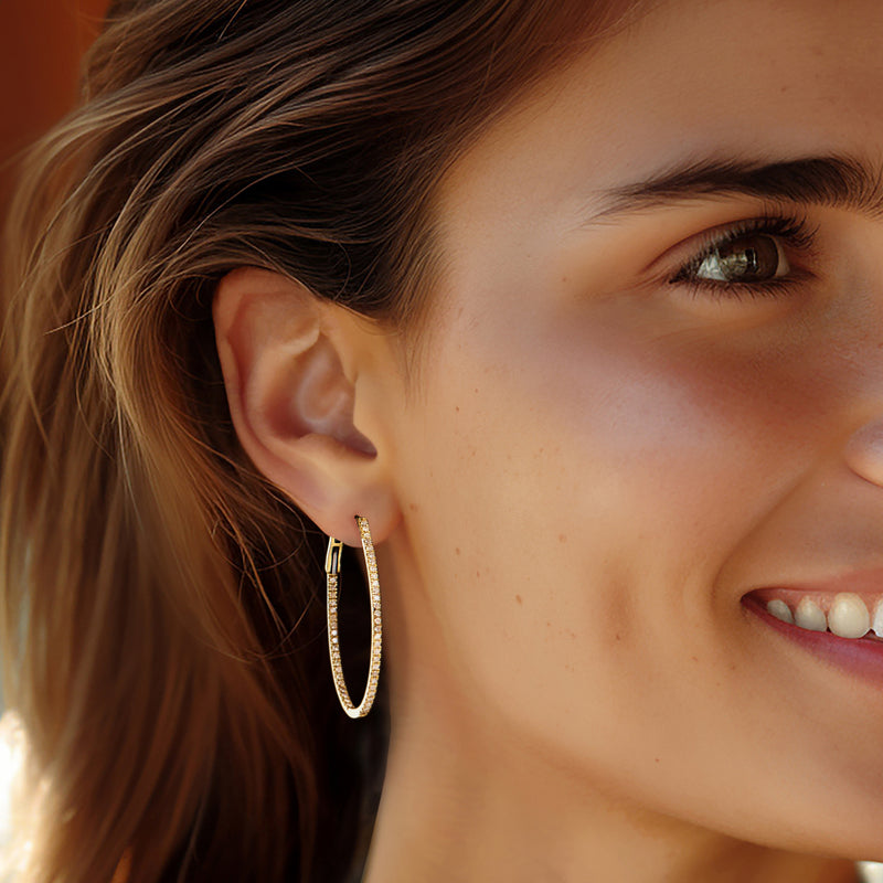 14kt yellow gold oval hoop earrings with diamonds, worn on ear