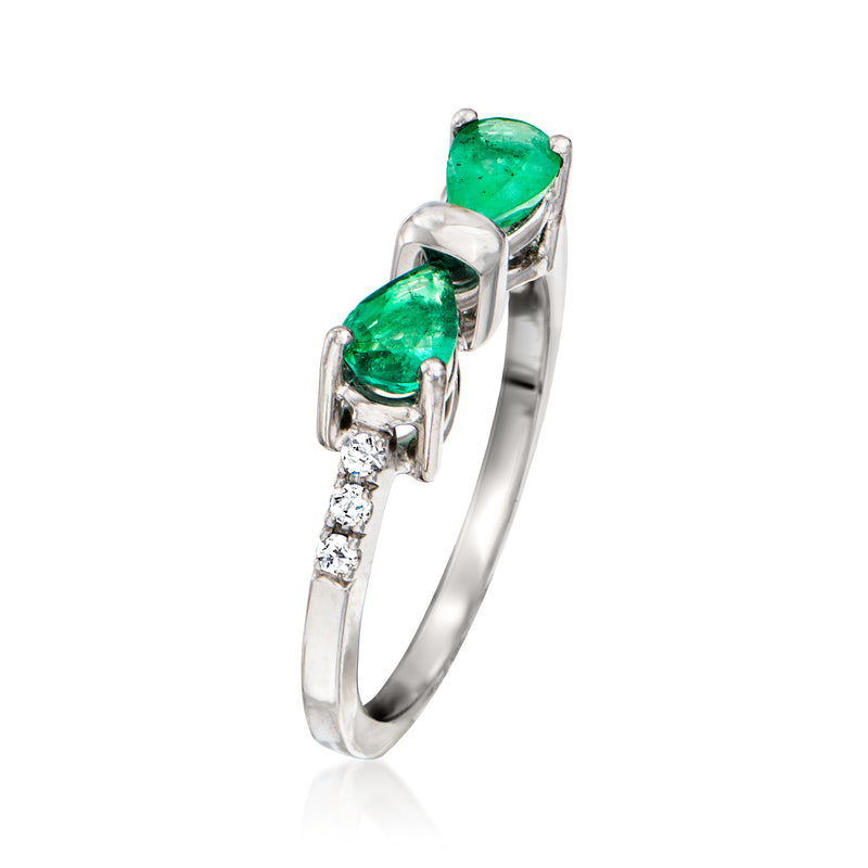 Side view of white gold emerald bow ring with two green stones and small diamond accents