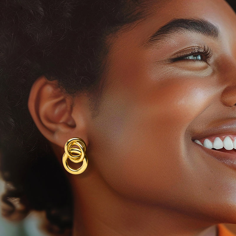 Yellow gold interlocking circle stud earrings on a model, close-up