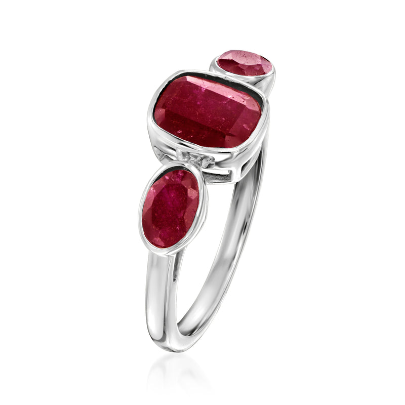 Sterling silver three-stone ring, angled view; cushion and two oval ruby red gems
