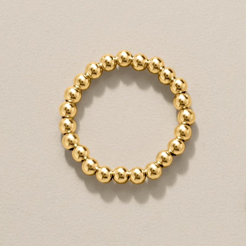 Yellow gold bead stretch ring, top view of a continuous beaded band