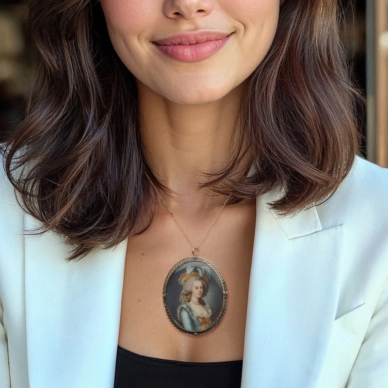 Oval portrait pendant pin worn on a thin gold chain, painted woman portrait in gold bezel