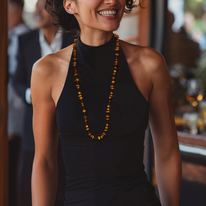 Amber bead necklace with 18kt yellow gold accents worn on a black sleeveless top
