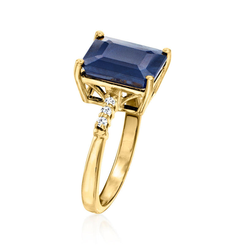 Gold-tone ring with blue rectangular sapphire in openwork claw setting and white zircons.