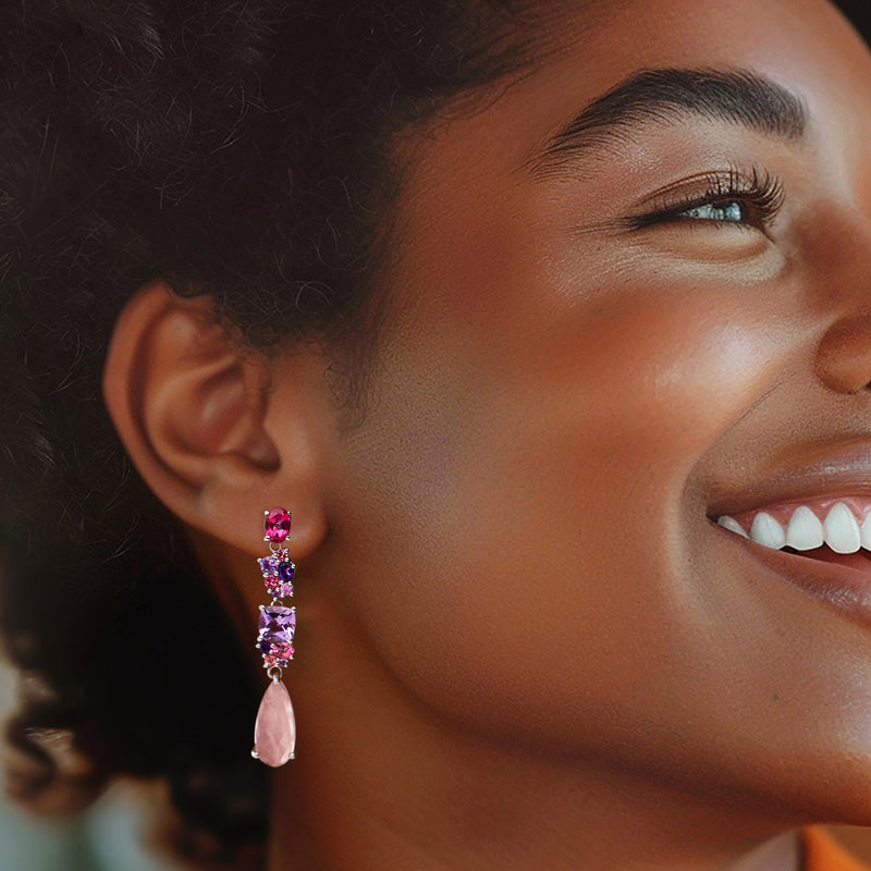 Worn sterling silver drop earrings with clustered pink and purple gemstones, side view