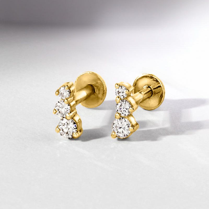 Graduated three-stone diamond stud earrings in 14kt yellow gold with flat backs
