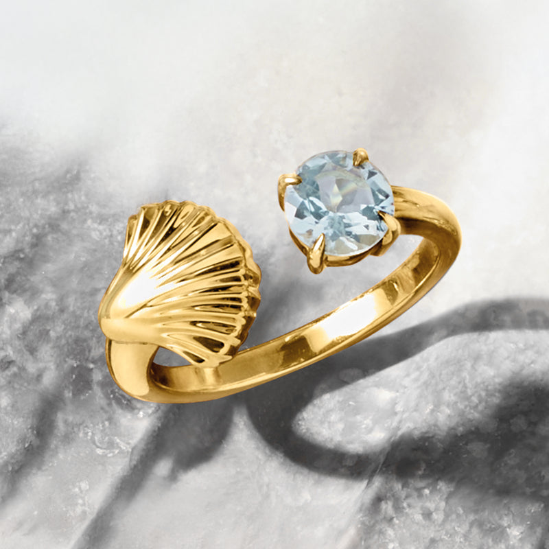Gold seashell open-space ring with oval aquamarine center stone, scalloped shell detail