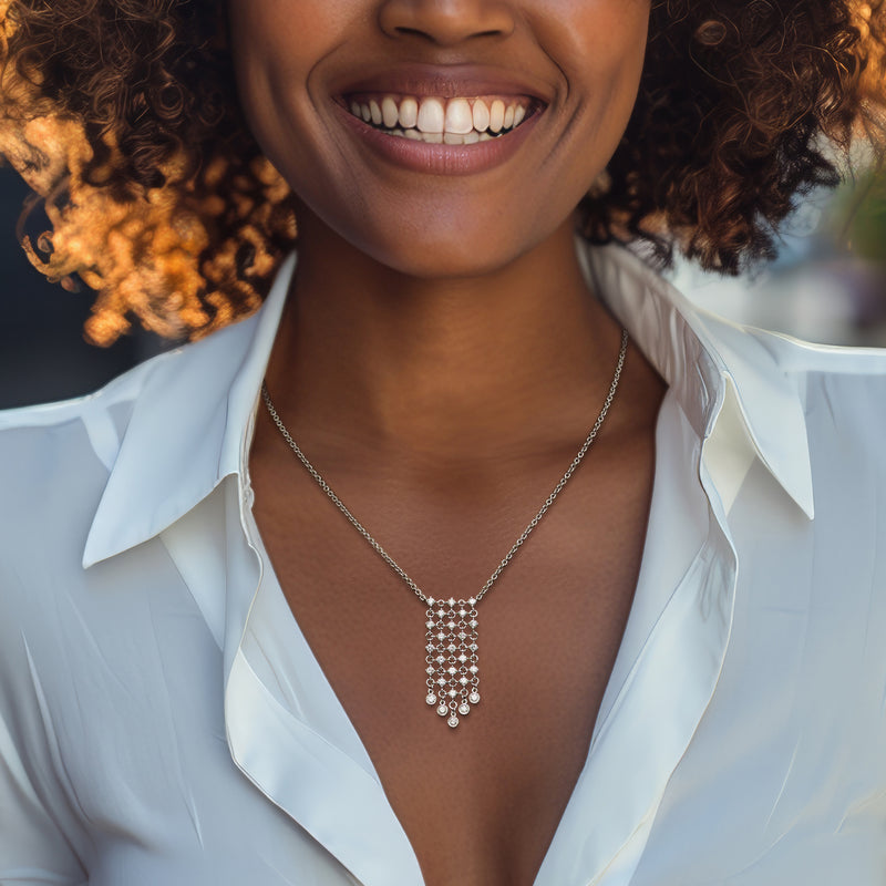 White gold diamond pendant bib necklace on open-collar blouse, choker-length chain