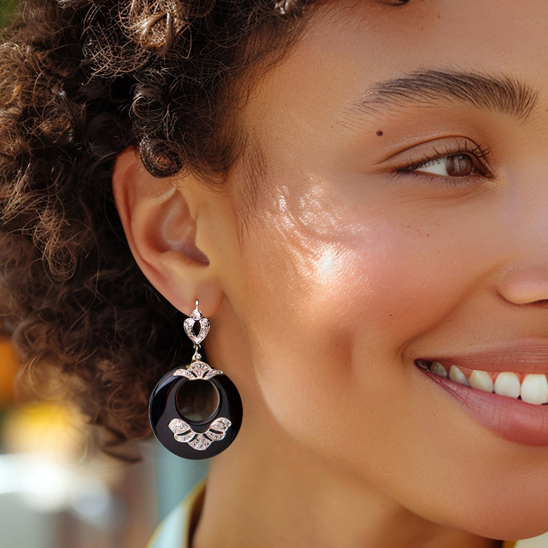 Onyx disc drop earrings with diamond cluster accents on model