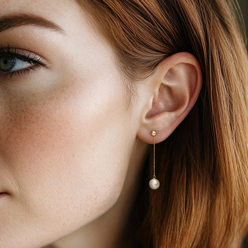 Cultured pearl drop earrings on a model with 10kt yellow gold rope chain