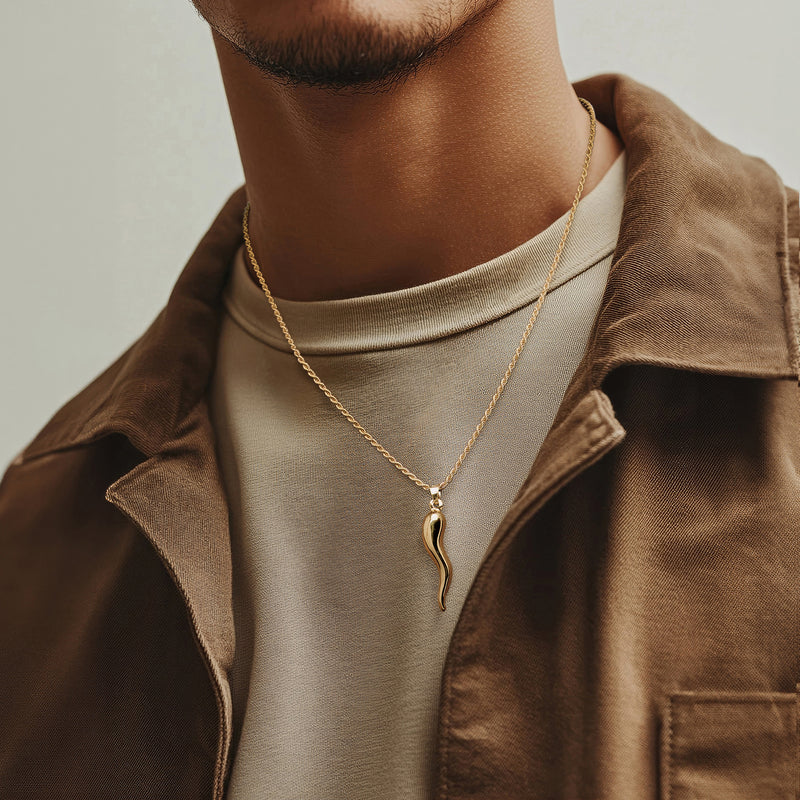 Gold-tone horn pendant necklace worn at collar, with thin chain
