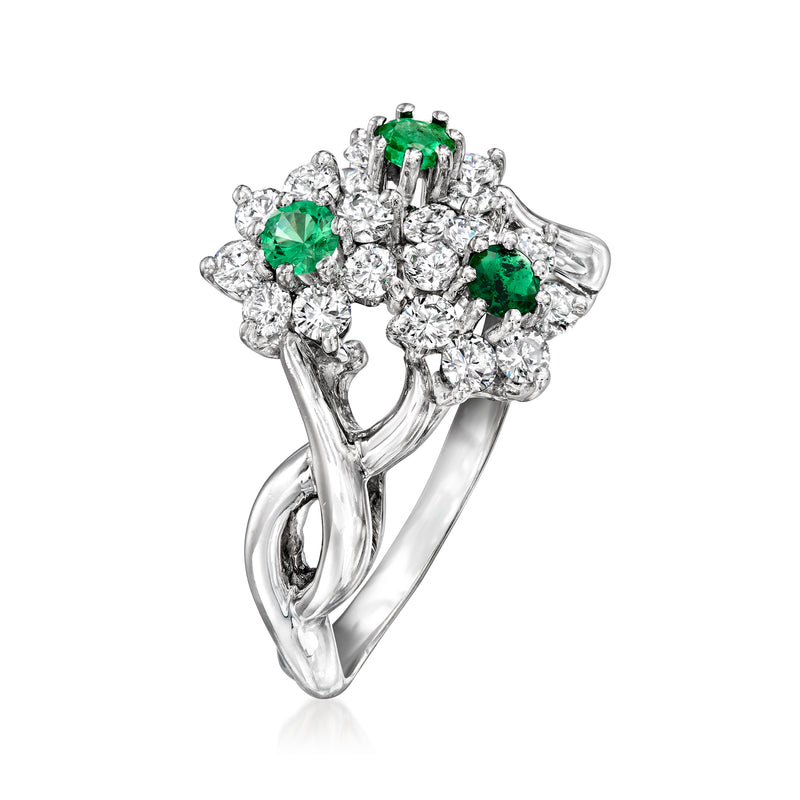 White gold flower ring angled view with three emerald-green centers and clear diamond halo