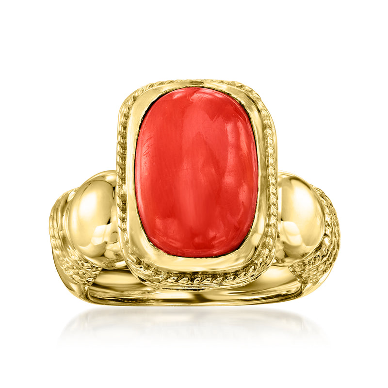 Vintage red coral cabochon ring in 14kt yellow gold with ornate bezel.