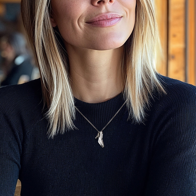 Stiletto heel pendant necklace worn on model, white gold with diamond accents