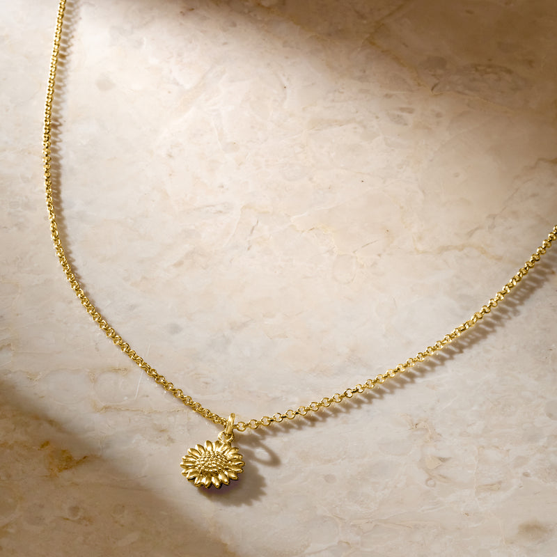 Gold-tone sunflower pendant necklace with round daisy charm on fine chain