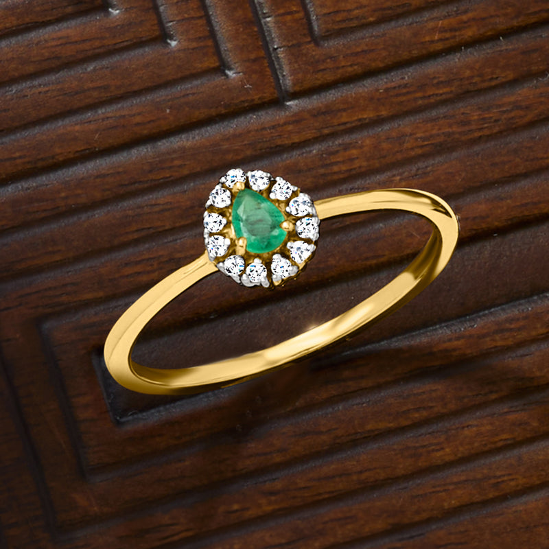 Yellow gold ring with oval emerald center and round diamond halo
