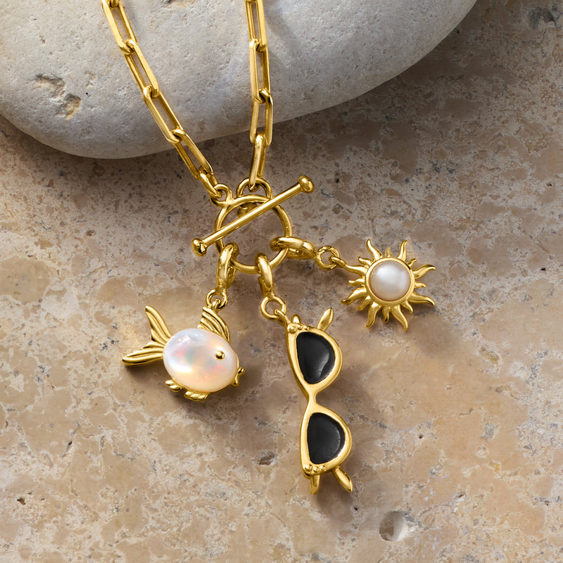 Gold charm with white cultured pearl sun pendant on a necklace chain
