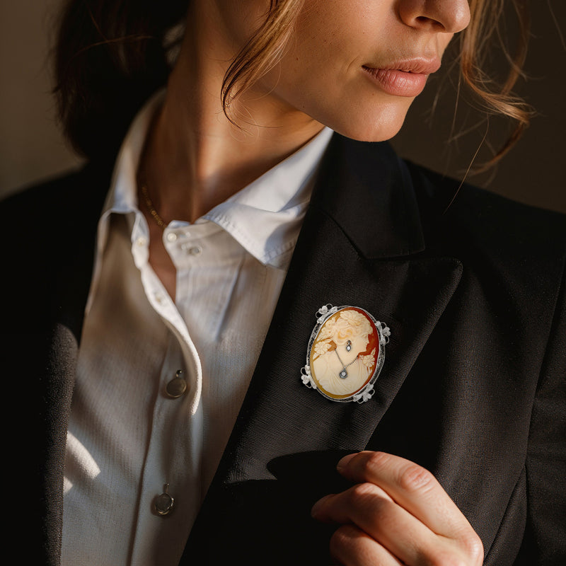 Brown shell cameo pin in 14kt white gold with diamond details, on blazer lapel