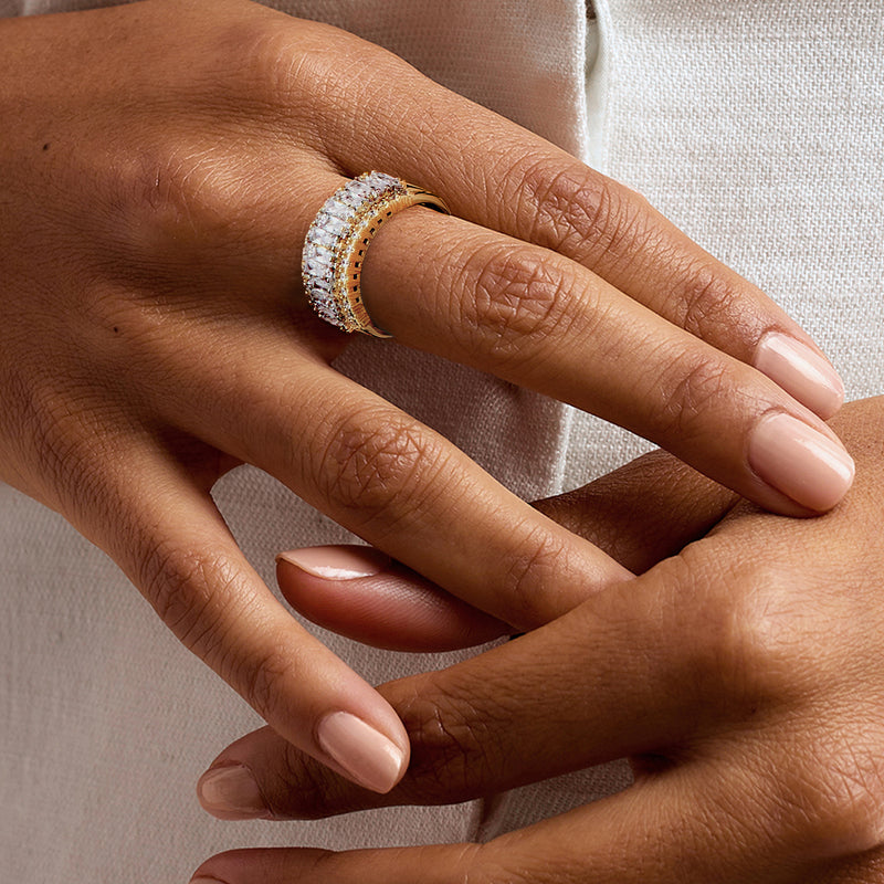Gold-tone CZ ring on hand, showing rectangular stones and round halo detail