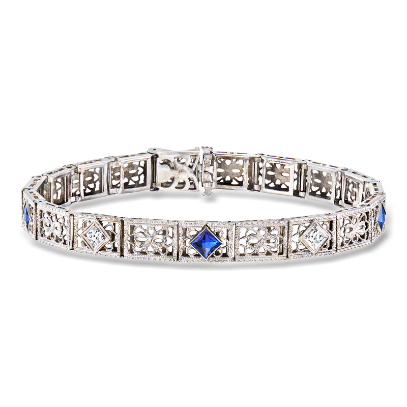 White gold bracelet with blue sapphire center and diamond accents, ornate filigree links