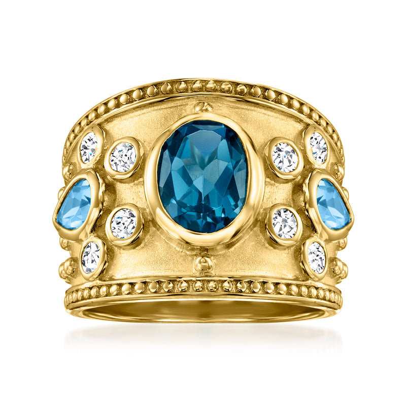 Gold-tone ring with oval blue gemstone and round clear stones in ornate bezel setting