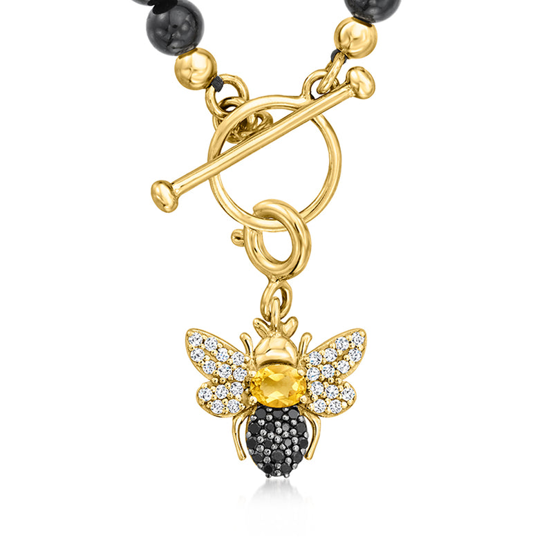Gold bee charm on black bead strand, with citrine center and jeweled wings