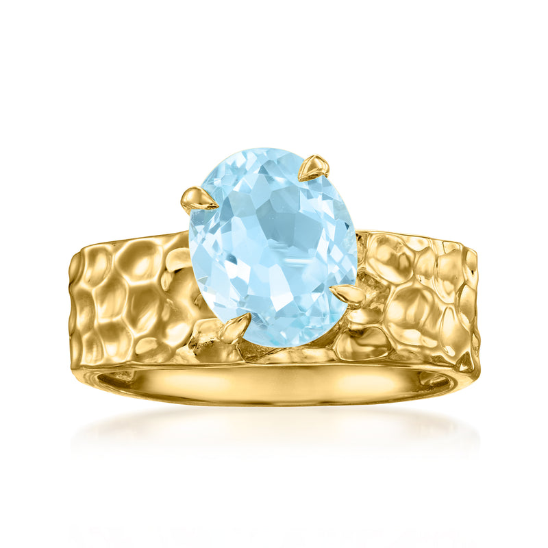 Gold ring with large light blue oval gemstone in hammered band
