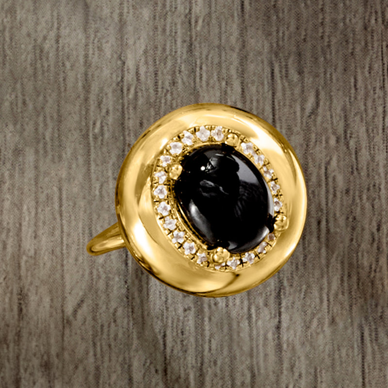 Close-up of gold over sterling ring: oval black gem surrounded by white topaz