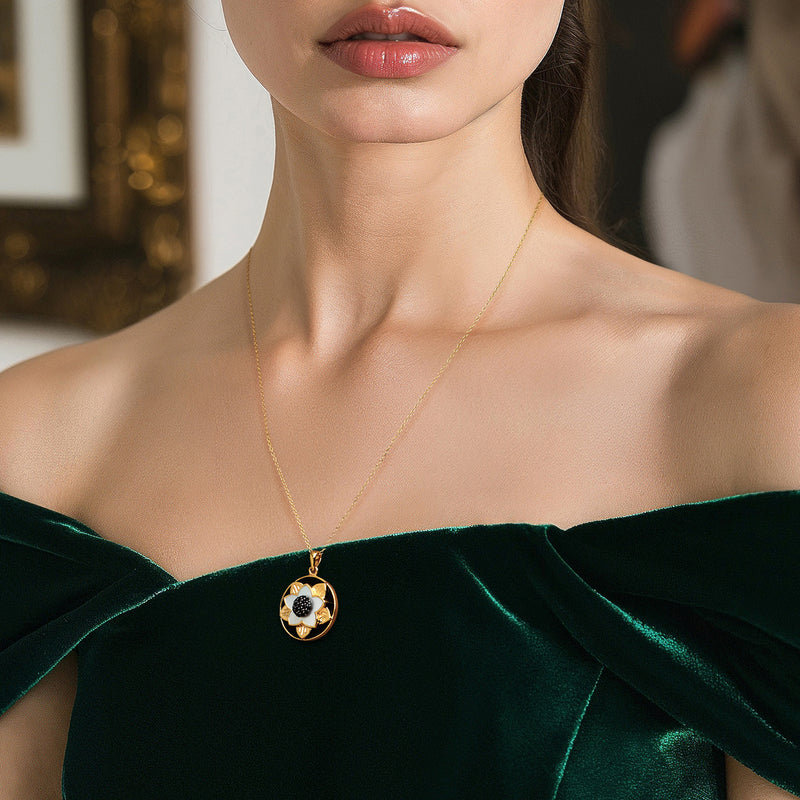 Gold pendant necklace with round flower pendant and black bead center, on model