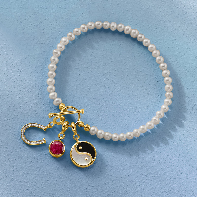 Pearl bracelet with gold horseshoe crescent charm and small dangling details