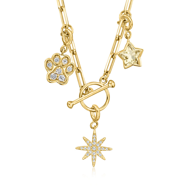 Gold paper-clip toggle necklace with paw charm, star, and sunburst charm