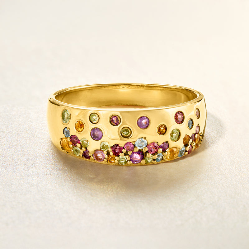Gold-tone multi-gemstone ring with rounded stones across the wide band