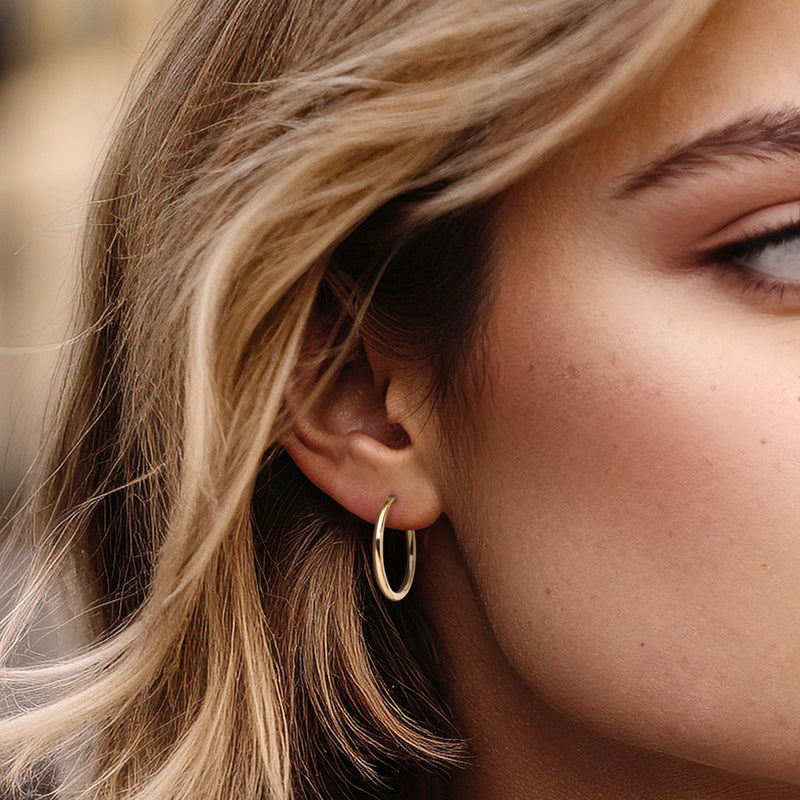 14kt yellow gold hoop earrings on ear, smooth round hoops