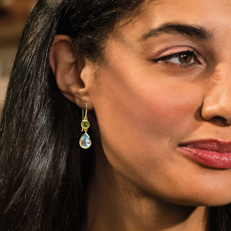 Gold-tone drop earrings with green peridot cap and light blue teardrop stone