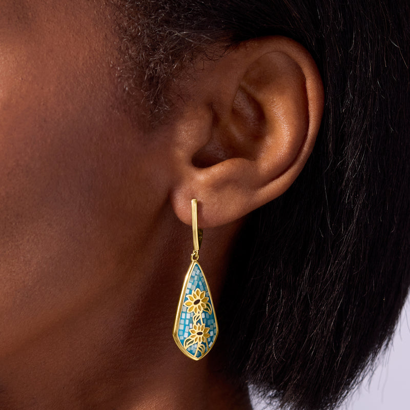 Gold drop earrings with blue teardrop enamel mosaic and sunflower motif, side view
